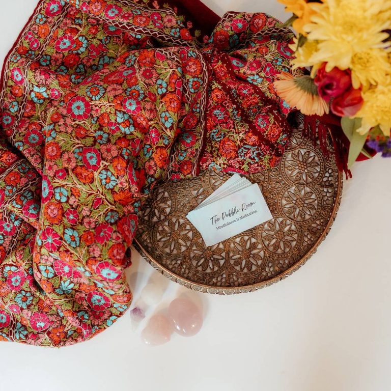 Top view of colourful flowers, throw, business cards and rose quartz